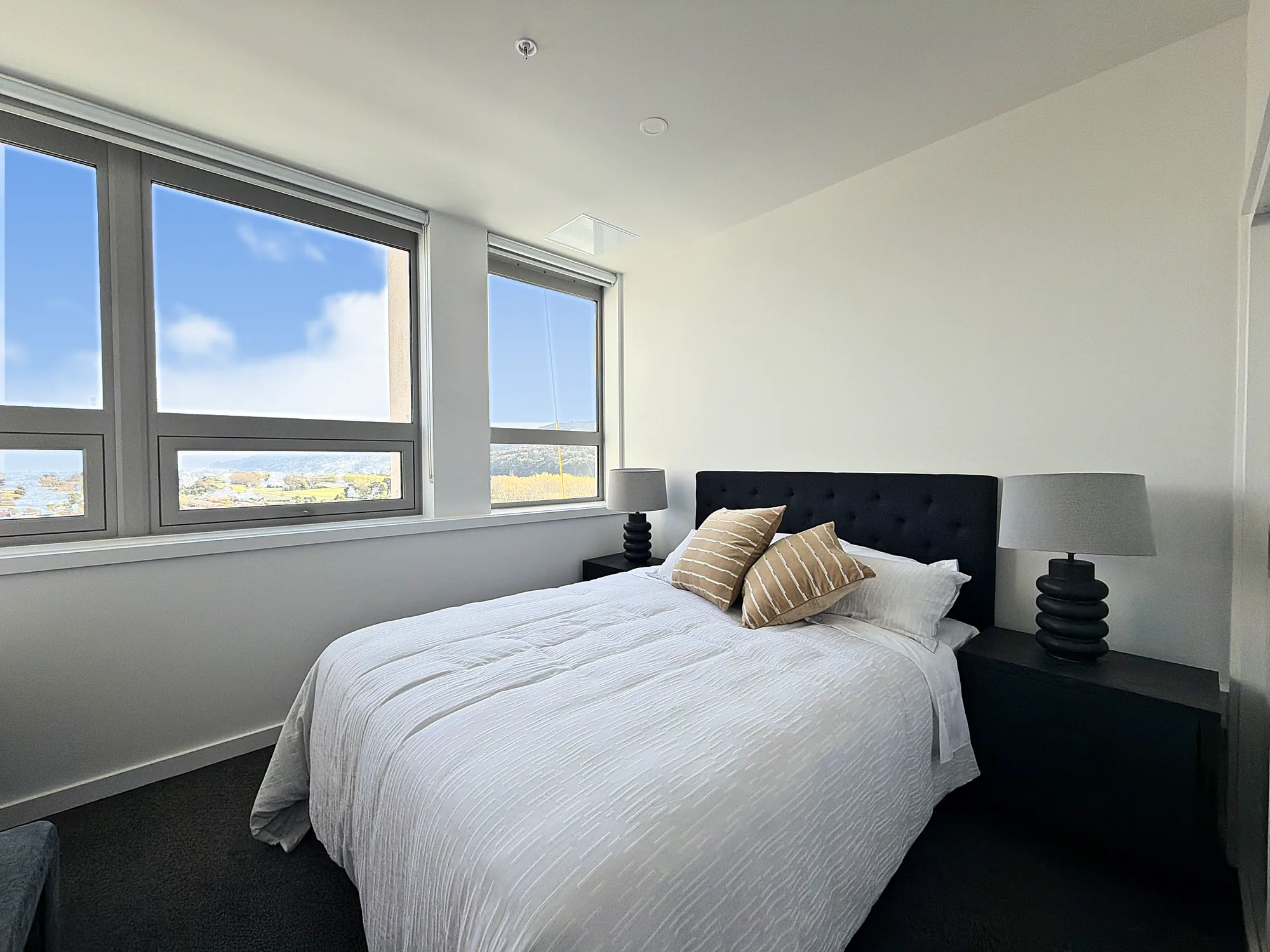 Second bedroom with windows across one wall in a two bedroom corner display home at Avalon Apartments, Lower Hutt